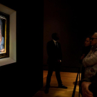Varias personas contemplan el cuadro “‘Salvator Mundi” del Leonardo.