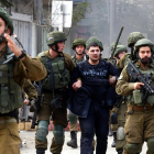 Soldats israelians, amb un manifestant palestí detingut, ahir, a Hebron.