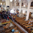 Personal de seguretat inspecciona l’interior de l’església de Tanta després de l’explosió d’una bomba.