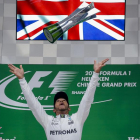 Lewis Hamilton lanza al aire el trofeo para festejar su victoria, flanqueado por Sebastian Vettel y Max Verstappen. 