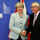 La primera ministra britànica, Theresa May, i el president de la Comissió Europea, Jean-Claude Juncker, es donen la mà abans de la reunió.