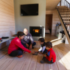 Una família juga en un bungalou amb llar de foc.