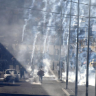 Varios palestinos corren tras el lanzamiento de botes lacrimógenos israelíes en Belén.