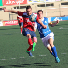 El jugador local Sergi protege el balón ante la presión de un futbolista visitante, en el encuentro disputado entre el Balaguer y el Morell.