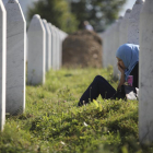 Una joven llora junto a la tumba de un familiar en Srebrenica.