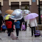 Varias personas caminan por Ciudad Real con paraguas.