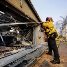 Un bombero trabaja en los restos incinerados de una vivienda en Anaheim Hills, California.