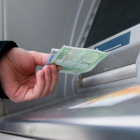 Imagen de archivo de una persona sacando dinero de un cajero automático.