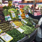 Una mujer escoge frutas y verduras en un supermercado.