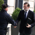 Mariano Rajoy, saludado por un policía ayer a su llegada al Congreso de los Diputados.
