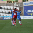Jordan Gaspar lluita per una pilota entre dos jugadors del Lleida en una acció del partit d’ahir.