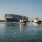 El portacontenedores Ever Given es remolcado tras salir de su embarrancamiento en el Canal de Suez.