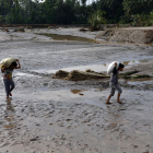 Ciudadanos filipinos transportan pertenencias a través de zonas inundadas.