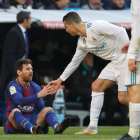 Cristiano Ronaldo ayuda a levantarse a Messi, figura del Barça.