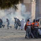 Palestinos se ponen a cubierto durante los enfrentamientos con la policía antidisturbios israelí.