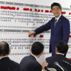 El primer ministre japonès, Shinzo Abe, posa un pin en forma de rosa al nom dels candidats.