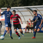 Un jugador de l’EFAC Almacelles surt amb la pilota controlada davant de la pressió de dos rivals.