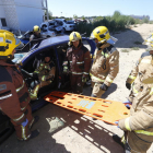Bombers professionals mostren als aspirants un exercici d’excarceració en un vehicle al parc de bombers de Lleida.