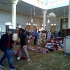 Varias personas permanecen junto a cuerpos sin vida en el interior de la mezquita. 