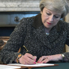 La primera ministra britànica, Theresa May, signa la carta del 'brexit'.
