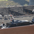 Operarios con trajes de protección cubren el amianto retirado de la cubierta del edificio de Mercolleida.