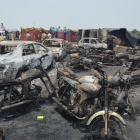 Cotxes i motos calcinats al lloc on va explotar el camió carregat de gasolina al Pakistan.