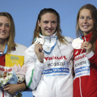 Mireia Belmonte mostra somrient la medalla amb l’hongaresa Hosszú i la canadenca Pickrem.