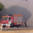 Imagen de dos bomberos luchando contra las llamas.