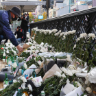 Un ciudadano deposita una flor en un altar por las víctimas.