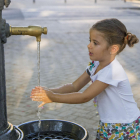 Una nena refrescant-se ahir a la tarda en una font a la capital del Segrià.