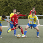 Un jugador de l’Organyà prova de colpejar la pilota davant la pressió de diversos rivals.