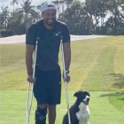 Tiger Woods, amb unes crosses, al costat del seu gos.
