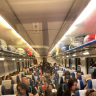Usuaris asseguts al passadís en un tren de l’R-13 de dimarts.