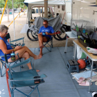 Dos turistas sentados en una parcela del camping La Noguera de Sant Llorenç de Montgai