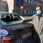 El propietario de un vehículo con el cristal roto por los balines. 