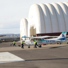 Una avioneta para formación de pilotos y, al fondo, hangares inflables y aviones aparcados en Alguaire.
