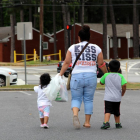 Imagen de archivo de una madre caminando con dos niños. 