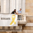 Dos treballadors comencen a treure la pancarta dels presos del Palau de la Generalitat el 2019.