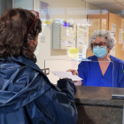 Una profesional de la Fundación Sant Hospital de la Seu d'Urgell entrega el documento con la baja médica al familiar de un paciente.