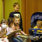 Infants arribats d'Ucraïna fugint de la guerra mirant contes a la biblioteca de Guissona