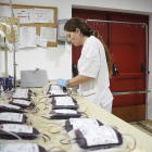 Fotografía de archivo que muestra a una empleada etiquetando bolsas de sangre.