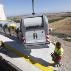 Un operario instalado los nuevos contenedores de recogida selectiva en Alfés en julio de 2018.