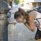 Una mujer se refresca en una fuente en Lleida por el calor en una imagen de archivo.