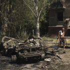 Un hombre pasea junto a un coche calcinado en Donetsk.