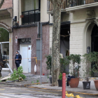 El carrer València, a l'altura del número 73, amb el local del costat afectat per l'explosió i la persiana cargolada a l'arbre
