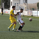 Un jugador local protegeix la pilota davant la pressió del rival.