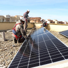 Operaris instal·lant plaques solars a la coberta d’un institut fa unes setmanes.