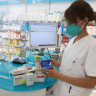 Una empleada de la farmacia Garròs de Lleida, con algunos de los medicamentos más vendidos.