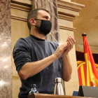 El secretari tercer de la Mesa, Pau Juvillà (CUP), retorna l'aplaudiment a l'hemicicle a l'inici del ple del Parlament del 14 de desembre.