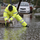 Un operario desagua una calle inundada de Manises, en València.
